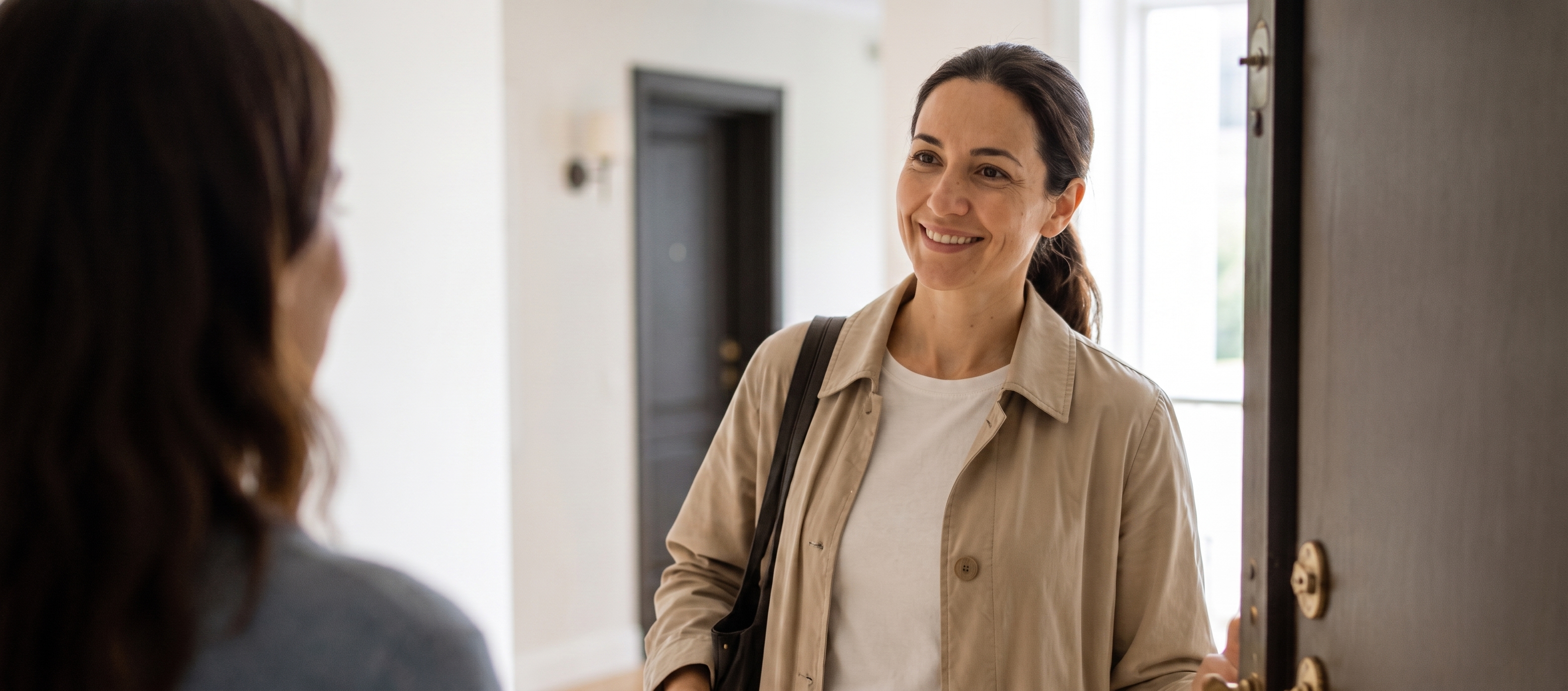 Client welcomed at her door by her cleaning professional